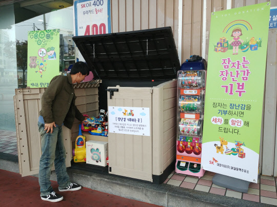 SK이노베이션은 지난 1일부터 SK에너지의 석유유통 협력사인 대양석유가 지난 1일부터 울산과 경기 동탄 등 전국 3곳의 주유소에서 소외계층 아동들에게 장난감을 기부하는 프로그램을 진행 중이라고 20일 밝혔다. 동탄드림주유소를 찾은 소비자가 집에서 쓰지 않는 장난감을 기부하고 있다. <SK이노베이션 제공>